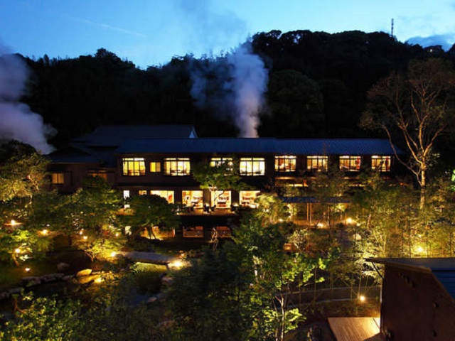 日本庭園と源泉櫓から立ち昇る湯気が、幻想的な雰囲気を演出します。