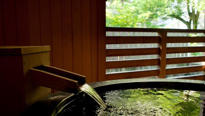 『松風庵』松声の間（102号室）の露天風呂。緑が映える幻想的なお風呂で朝湯をどうぞ。